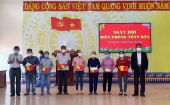 Đồng chí Nguyễn Xuân Vĩnh và đồng chí Lê Tự Hồng tặng cờ Tổ quốc, quà cho gia đình ngư dân có hoàn cảnh khó khăn