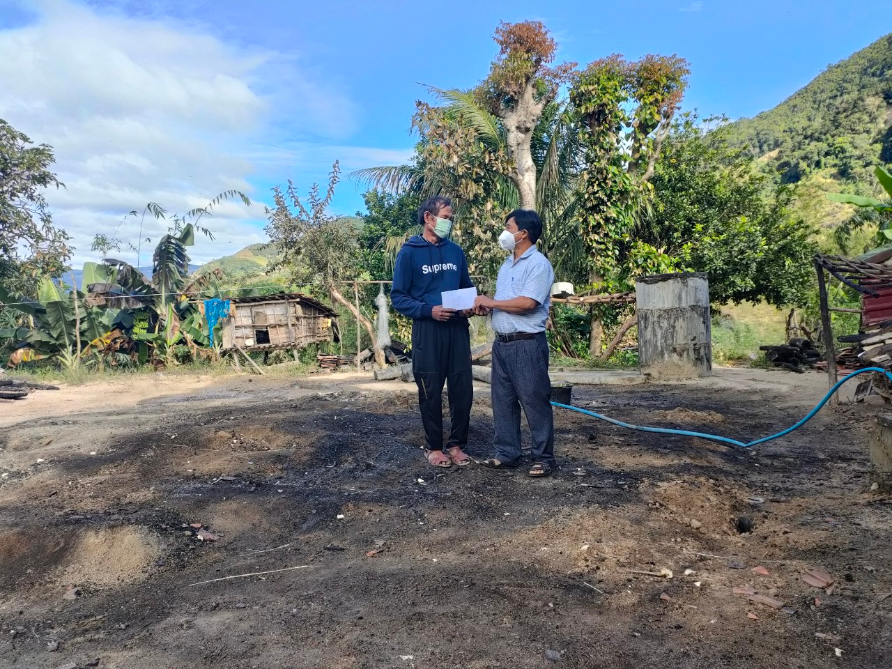 Ông Đinh A Zơn - Ủy viên Ban Thường vụ Huyện ủy, Trưởng ban Ban dân vận Huyện ủy, Chủ tịch Ủy ban MTTQ Việt Nam huyện trao tiền hỗ trợ cho gia đình