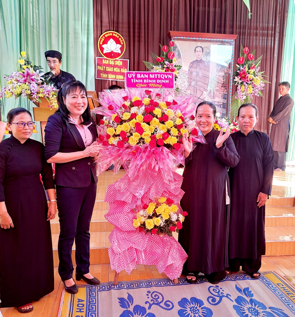 Bà Hồ Thị Kim Thu - Phó Chủ tịch Ủy ban MTTQ Việt Nam tỉnh tặng hoa chúc mừng đại lễ