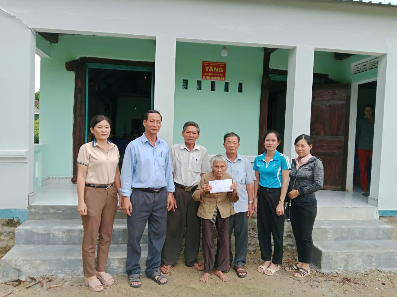 Đoàn công tác trao tiền hỗ trợ xây nhà cho bà Trần Thị lang thôn An Hòa 2